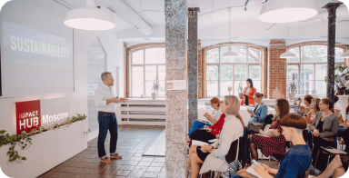 Фотография мужчины, выступающего с презентацией перед сидящими людьми